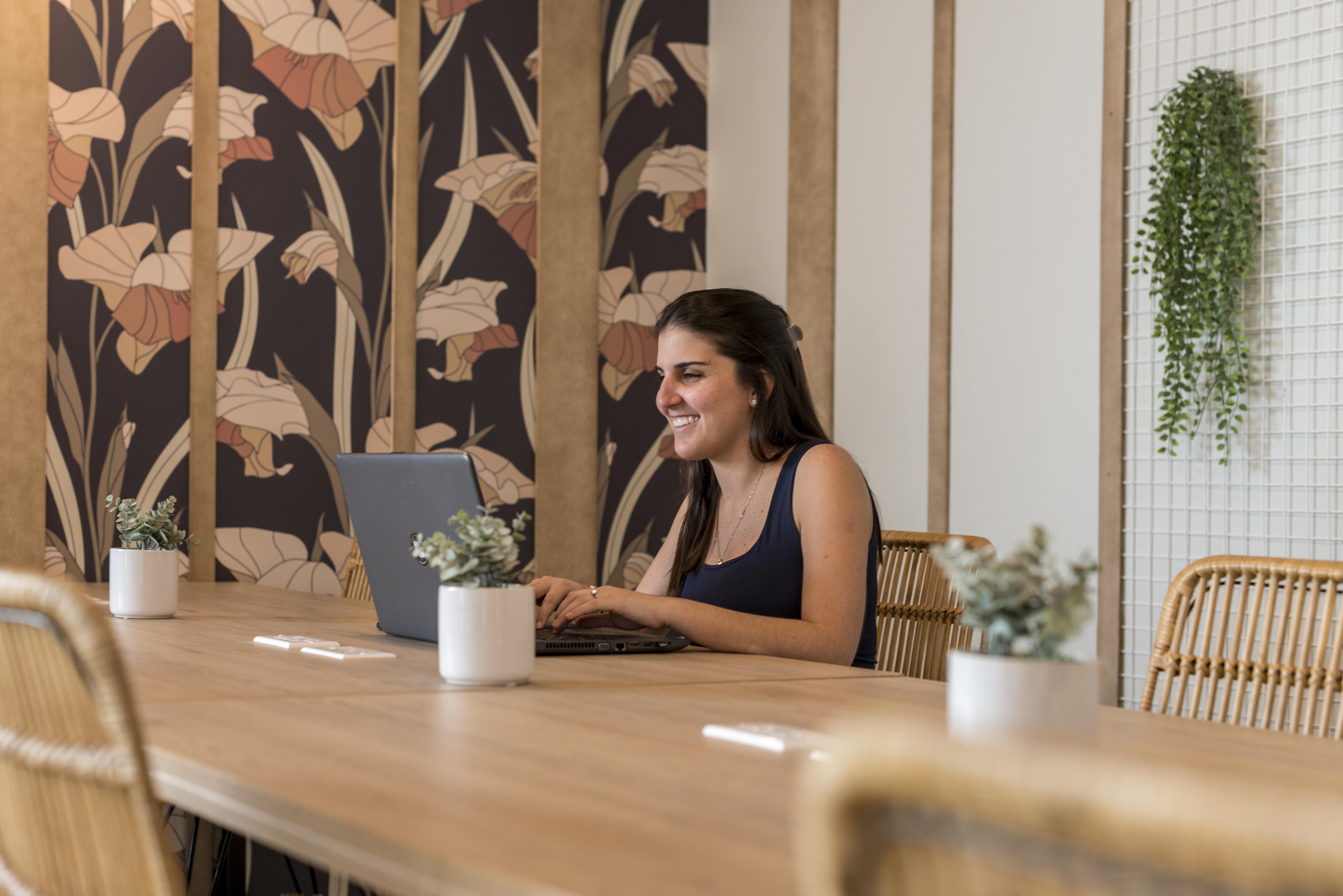 mujer joven trabajando con su laptop en un coworking